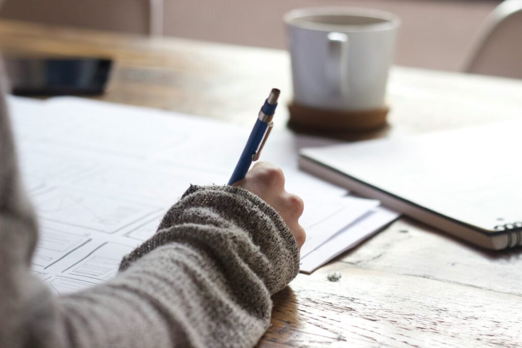 Someone making notes by hand in an open notebook